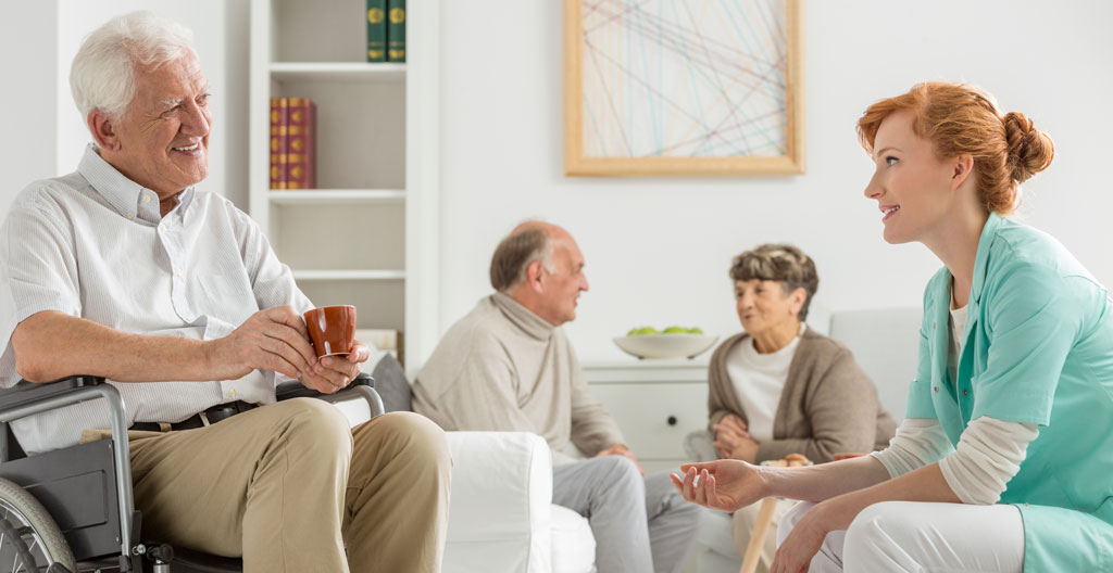 Personnel d'établissement présentant un espace commun à une famille lors d'une visite